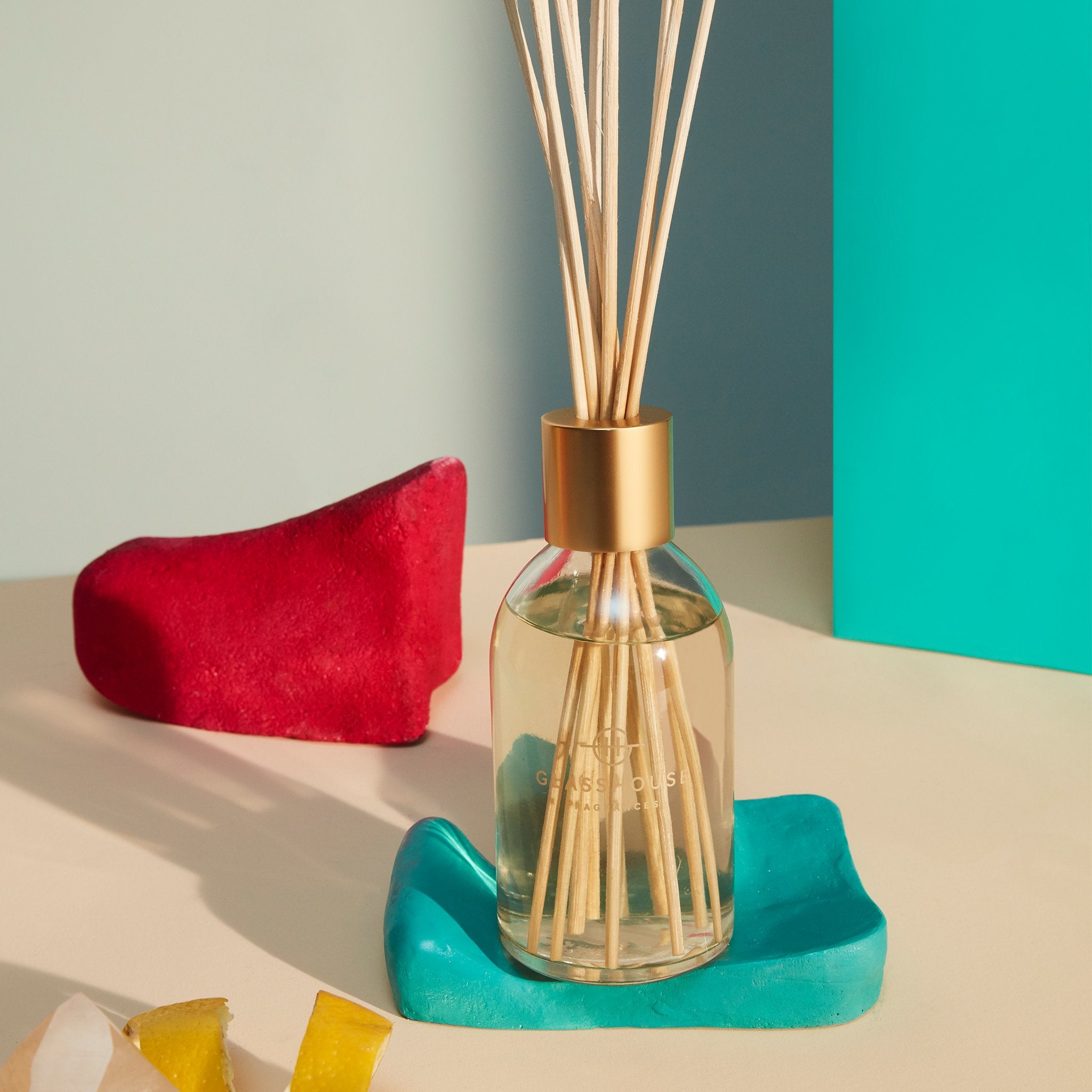 Glasshouse Fragrances fragrance diffuser on tabletop surrounded by coloured ornaments